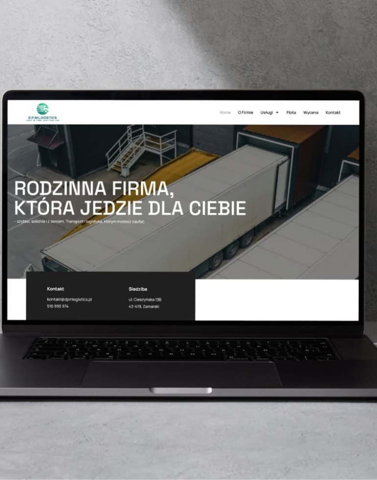 Laptop stojący na betonowym blacie z wyświetloną stroną D.P.M Logistics, na ekranie zdjęcie ciężarówek i napis Rodzinna firma, która jedzie dla Ciebie